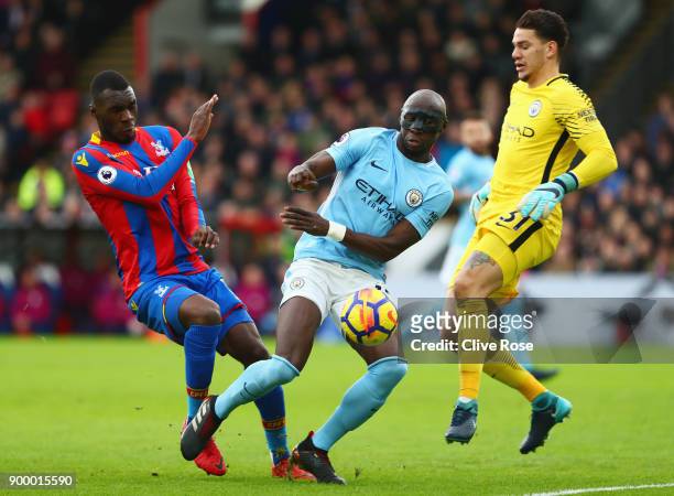 Christian Benteke of Crystal Palace is foiled by Eliaquim Mangala and Ederson of Manchester City during the Premier League match between Crystal...