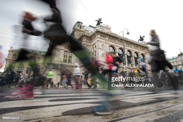 Runners take part in the 41st Vienna New Year's Eve run on the Ringstrasse in front of the State Opera on December 31, 2017 in Vienna. The circular...