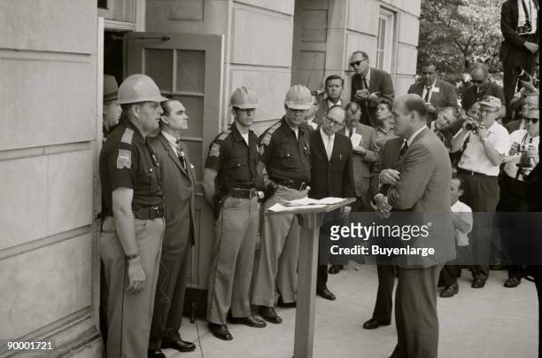 Governor George Wallace attempting to block integration at the University of Alabama; Gov. Wallace standing defiantly at a door while being...