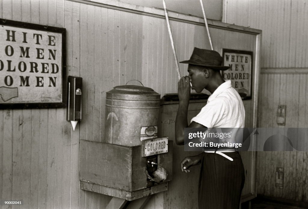 Negro drinking at "Colored" water cooler in streetcar terminal, Oklahoma City, Oklahoma
