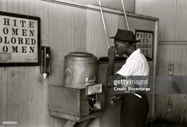 Negro drinking at "Colored" water cooler in streetcar terminal, Oklahoma City, Oklahoma