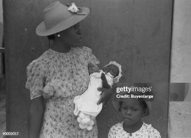 Charlotte Amalie, St. Thomas Island, Virgin Islands. Mother and children waiting on the main street on Sunday