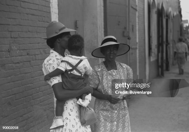 Charlotte Amalie, St. Thomas Island, Virgin Islands. Mother and children waiting on the main street on Sunday