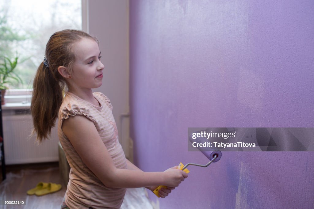 Repairs in the apartment. Girl paints the wall with ultraviolet paint - trend 2018