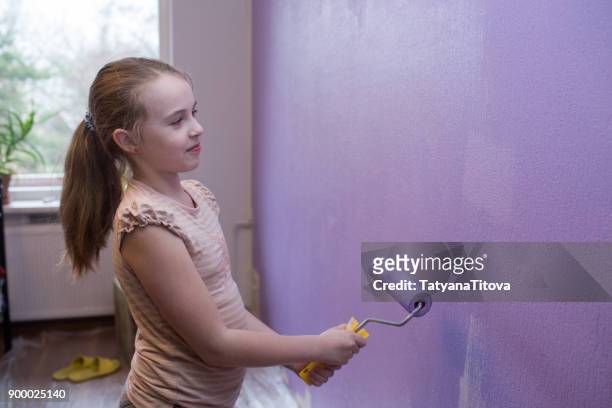 repairs in the apartment. girl paints the wall with ultraviolet paint - trend 2018 - latvia girls stock pictures, royalty-free photos & images