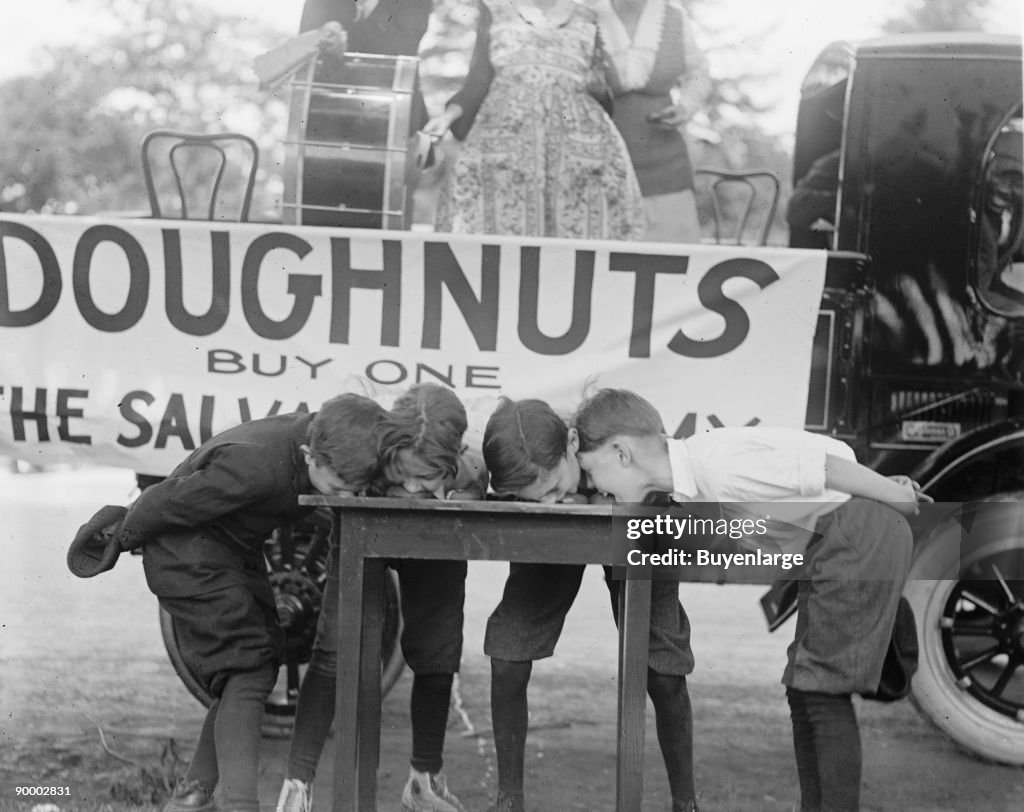 Boys Chow Down on a Table in a Donut Eating Contest