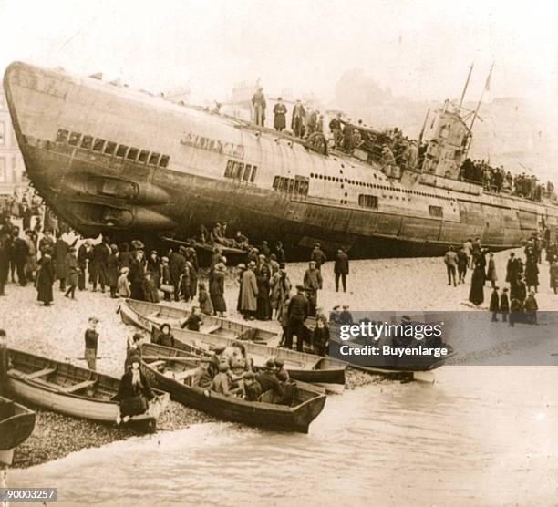 Boats stranded on the south coast of England after surrender surrounded by onlookers on foot and who have arrived by boat