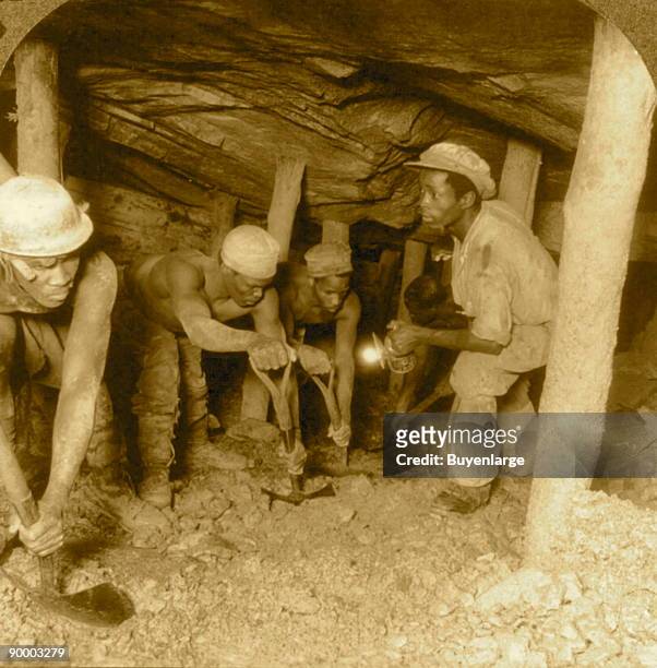 Human moles follow the compressed air drill - developing a drift in the greatest gold bearing region of the world, Crown Mine, Johannesburg, S. Africa