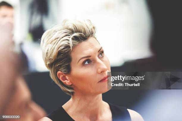 businesswoman listening during meeting - shareholder's meeting stock pictures, royalty-free photos & images