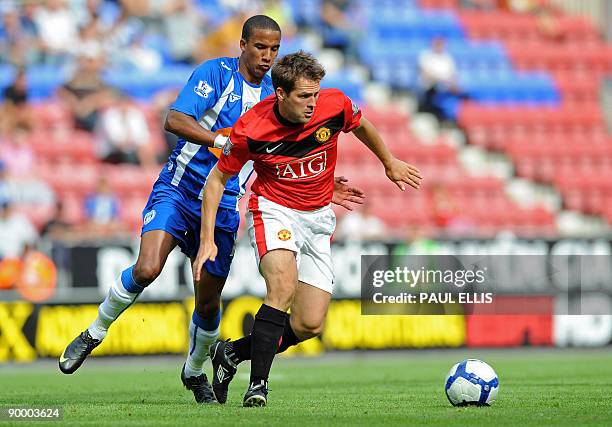 Wigan Athletic's English forward Scott Sinclair competes for the ball with Manchester United's English forward Michael Owen during the English...