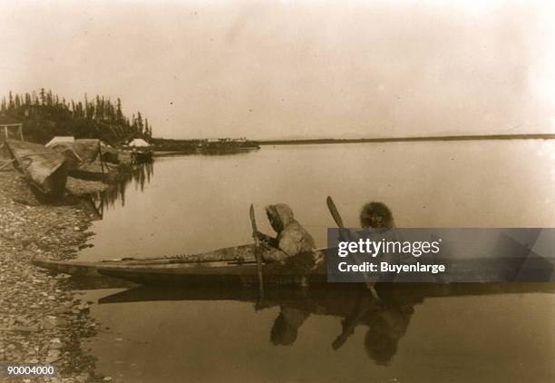 Two Eskimos in kayak.