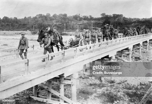 Japanese Mountain Artillery crossing river bridge with horses pulling caissons