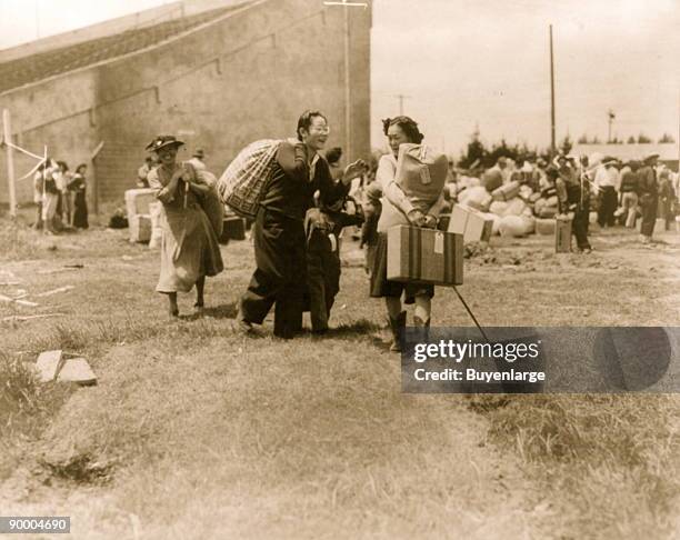 Two Japanese evacuee families meeting at assembly center, Salinas rodeo grounds during internment procedure