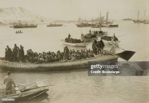 String of pontoons in tow of stream launch, approaching landing stage with load of Japanese infantry troops