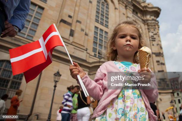 Young girl waves a Danish flag as Queen Margrethe II of Denmark and Governor of Saxony Stanislaw Tillich visit the Frauenkirche on August 22, 2009 in...