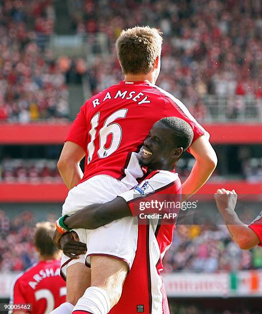 Arsenal's Welsh player Aaron Ramsey celebrates scoring Arsenal's fourth goal with Emmanuel Eboue during the Premier League football match between...