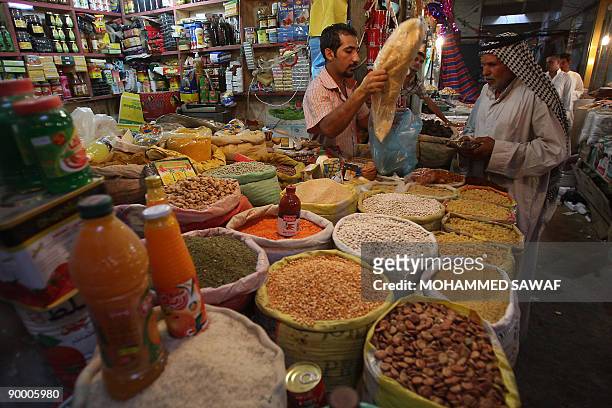 An Iraqi vendor serves a customer at a market in Karbala, 100 kms south of Baghdad, on the first day of the Muslim fasting month of Ramadan on August...