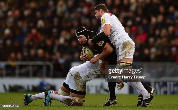 Thomas Waldrom of Exeter Chiefs is tackled by Michael Fitzgerald and Tafafu Polota-Nau of Leicester Tigers during the Aviva Premiership match between...