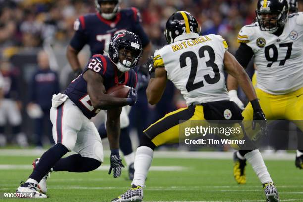 Lamar Miller of the Houston Texans runs the ball defended by Mike Mitchell of the Pittsburgh Steelers and Cameron Heyward in the first half at NRG...