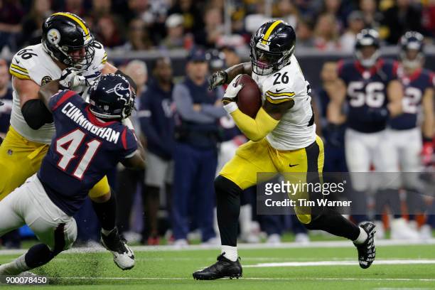 Le'Veon Bell of the Pittsburgh Steelers runs the ball as David DeCastro blocks Zach Cunningham of the Houston Texans in the second half at NRG...