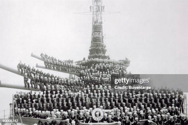 Of the 1052 compliment of sailors pose on the deck of the USS Texas . They sit on the massive 14 inch guns on this US Navy battleship. The Texas was...