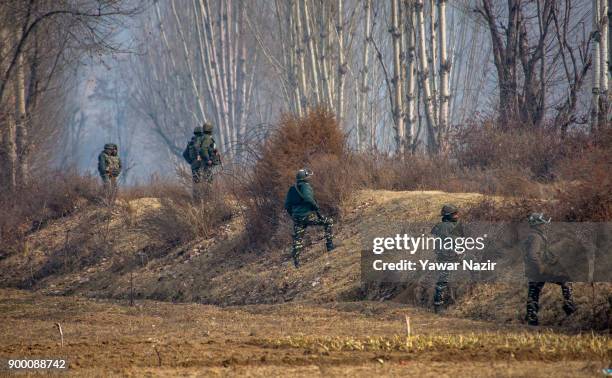 Indian government forces stand alert alert near the site of gun battle between Indian government forces and Kashmiri Muslim rebels on December 31,...