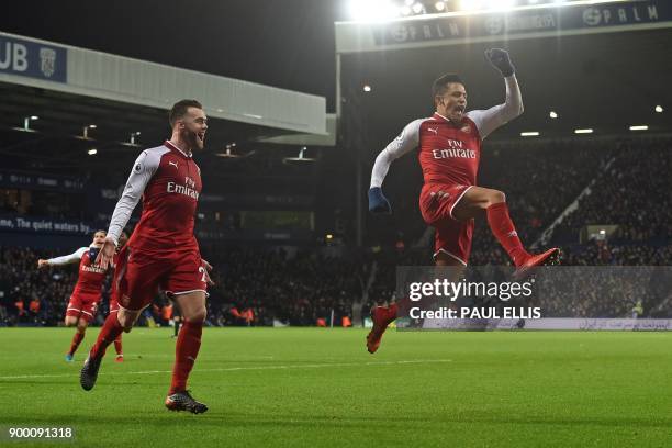 Arsenal's Chilean striker Alexis Sanchez celebrates after scoring the opening goal with a deflected free kick during the English Premier League...