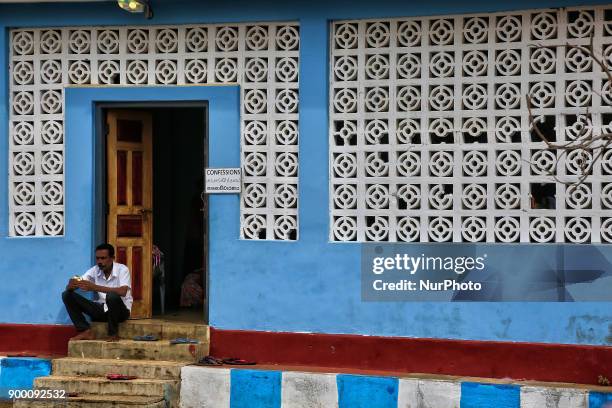 Tamil Catholic man sits on the steps of the confessional building after giving his confession at the Church of Our Lady of Madhu in Mannar, Sri...