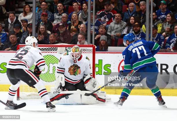 Gustav Forsling of the Chicago Blackhawks looks on as Anton Forsberg of the Chicago Blackhawks makes a save off Nikolay Goldobin of the Vancouver...