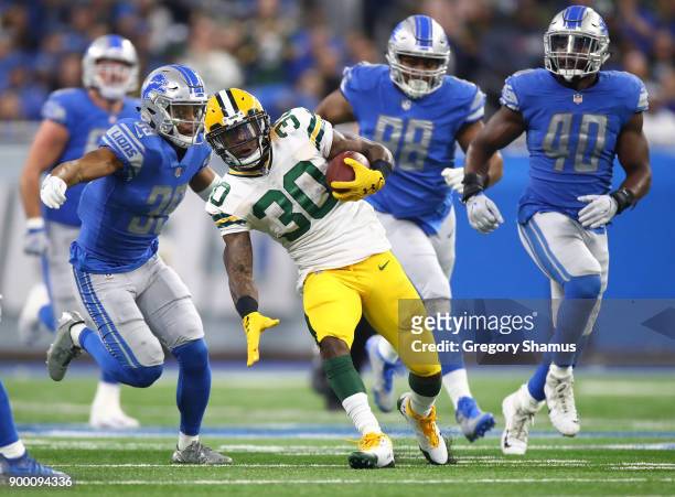 Jamaal Williams of the Green Bay Packers runs for yardage against Jamal Agnew of the Detroit Lions, Jeremiah Ledbetter and Jarrad Davis of the...