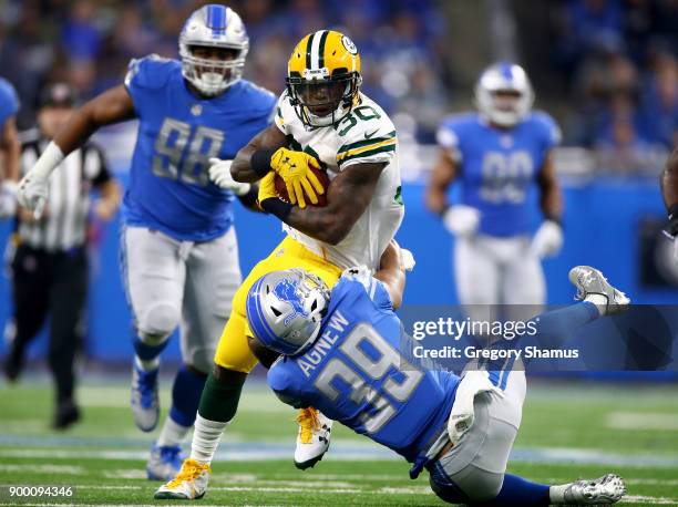 Jamaal Williams of the Green Bay Packers runs for yardage against Jamal Agnew of the Detroit Lions during the first quarter at Ford Field on December...