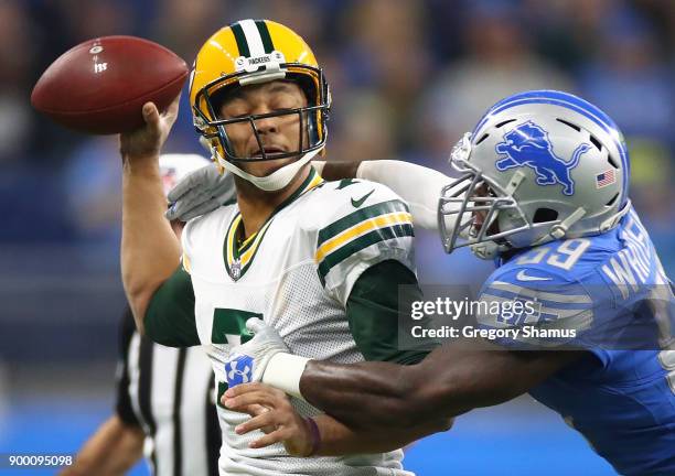 Brett Hundley of the Green Bay Packers is wrapped up by Tahir Whitehead of the Detroit Lions during the first quarter at Ford Field on December 31,...