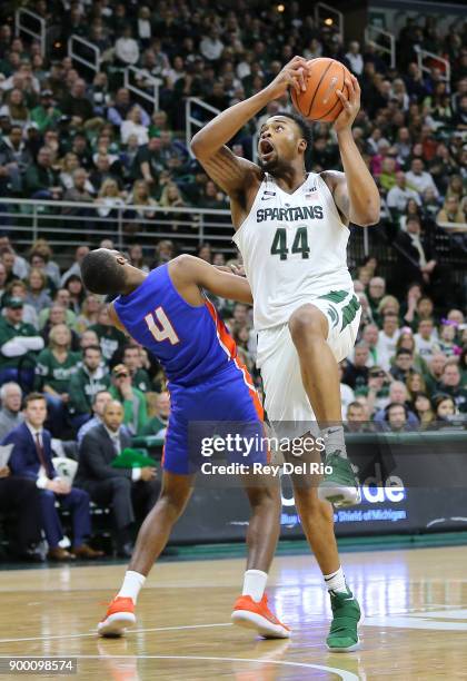 Nick Ward of the Michigan State Spartans shoots a layup against John Grant Jr. #4 of the Savannah State Tigers at Breslin Center on December 31, 2017...