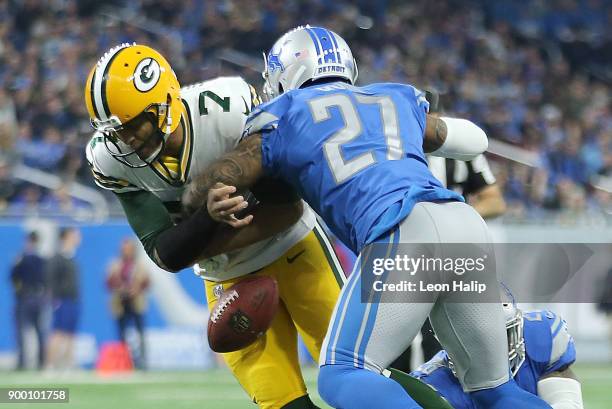 Quarterback Brett Hundley of the Green Bay Packers fumbles the ball as he is hit by Glover Quin of the Detroit Lions during the first half at Ford...