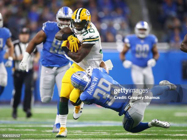 Jamaal Williams of the Green Bay Packers runs for yardage against Jamal Agnew of the Detroit Lions during the first quarter at Ford Field on December...