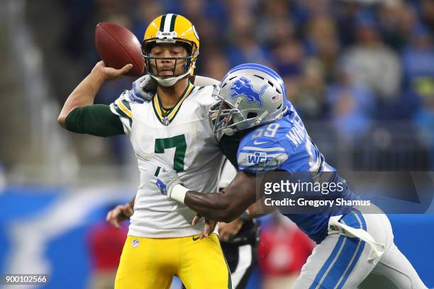 Brett Hundley of the Green Bay Packers is wrapped up by Tahir Whitehead of the Detroit Lions during the first quarter at Ford Field on December 31,...