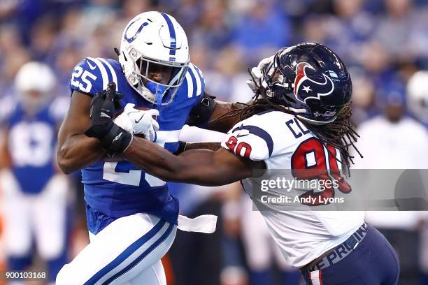 Marlon Mack of the Indianapolis Colts pushes off a tackle from Jadeveon Clowney of the Houston Texans during the second half at Lucas Oil Stadium on...