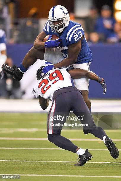 Frank Gore of the Indianapolis Colts jumps over Andre Hal of the Houston Texans during the second half at Lucas Oil Stadium on December 31, 2017 in...