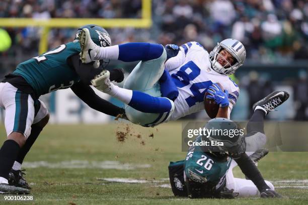 Tight end James Hanna of the Dallas Cowboys is tackled by cornerback Rasul Douglas and cornerback Jaylen Watkins of the Philadelphia Eagles during...