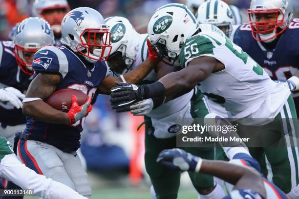 Dion Lewis of the New England Patriots carries the ball against Demario Davis of the New York Jets during the second half at Gillette Stadium on...
