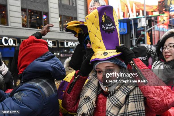 Spectators put on their party hats in Times Square ahead of the New Year's Eve celebration on December 31, 2017 in New York City.