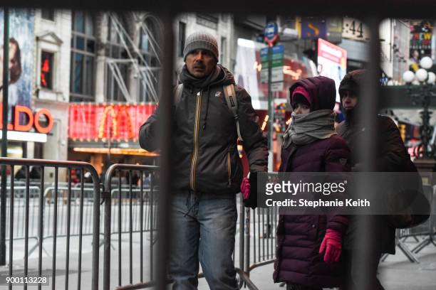 Pedestrians navigate the security barriers in Times Square ahead of the New Year's Eve celebration on December 31, 2017 in New York City.