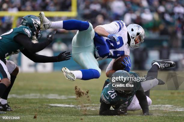 Tight end James Hanna of the Dallas Cowboys is tackled by cornerback Rasul Douglas and cornerback Jaylen Watkins of the Philadelphia Eagles during...