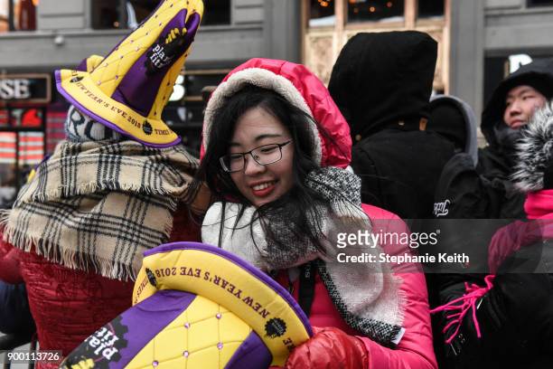 Spectators put on their party hats in Times Square ahead of the New Year's Eve celebration on December 31, 2017 in New York City.