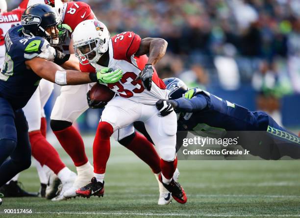 Running back Kerwynn Williams of the Arizona Cardinals is tackled by linebacker K.J. Wright of the Seattle Seahawks and Bradley McDougald in the...