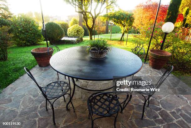 italian garden patio on a colorful autumn day - metal patio table stock pictures, royalty-free photos & images