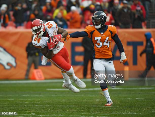 Kansas City Chiefs tight end Demetrius Harris catches a pass in front of Denver Broncos defensive back Will Parks during the first quarter on...