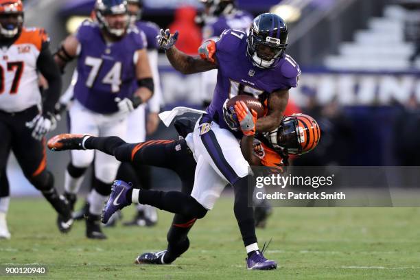 Wide Receiver Mike Wallace of the Baltimore Ravens runs with the ball as he is tackled by cornerback Dre Kirkpatrick of the Cincinnati Bengals in the...