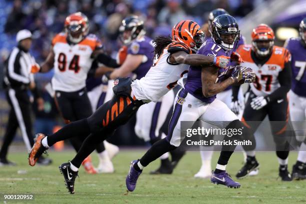 Wide Receiver Mike Wallace of the Baltimore Ravens runs with the ball as he is tackled by cornerback Dre Kirkpatrick of the Cincinnati Bengals in the...