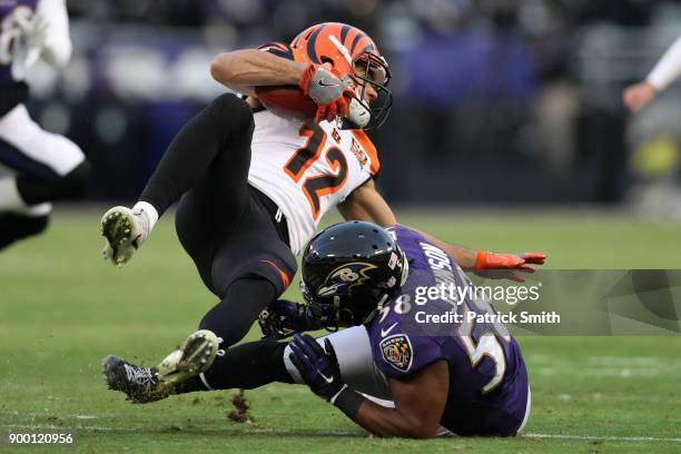 Wide Receiver Alex Erickson of the Cincinnati Bengals is tackled during a kick return by linebacker Steven Johnson of the Baltimore Ravens in the...